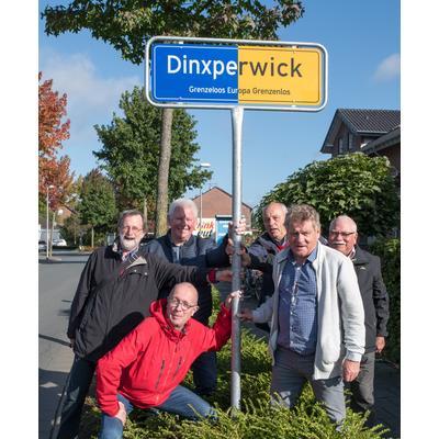 Das neue Ortsschild an der Sporker Straße umsäumt von Einwohnern.